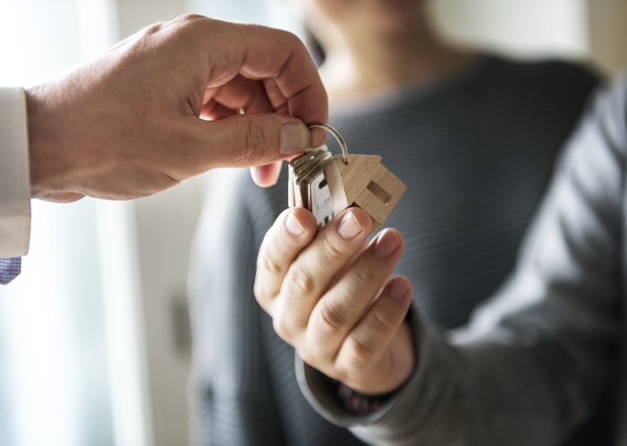real estate agent giving house key to the home buyer
