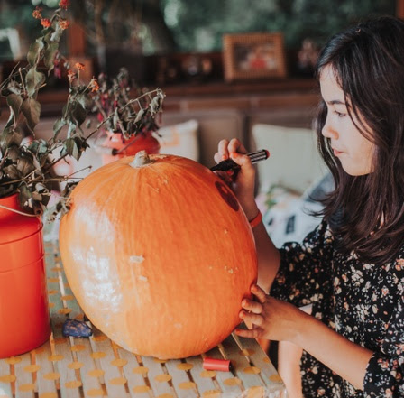 one girl decorating and painting pumpkin for halloween